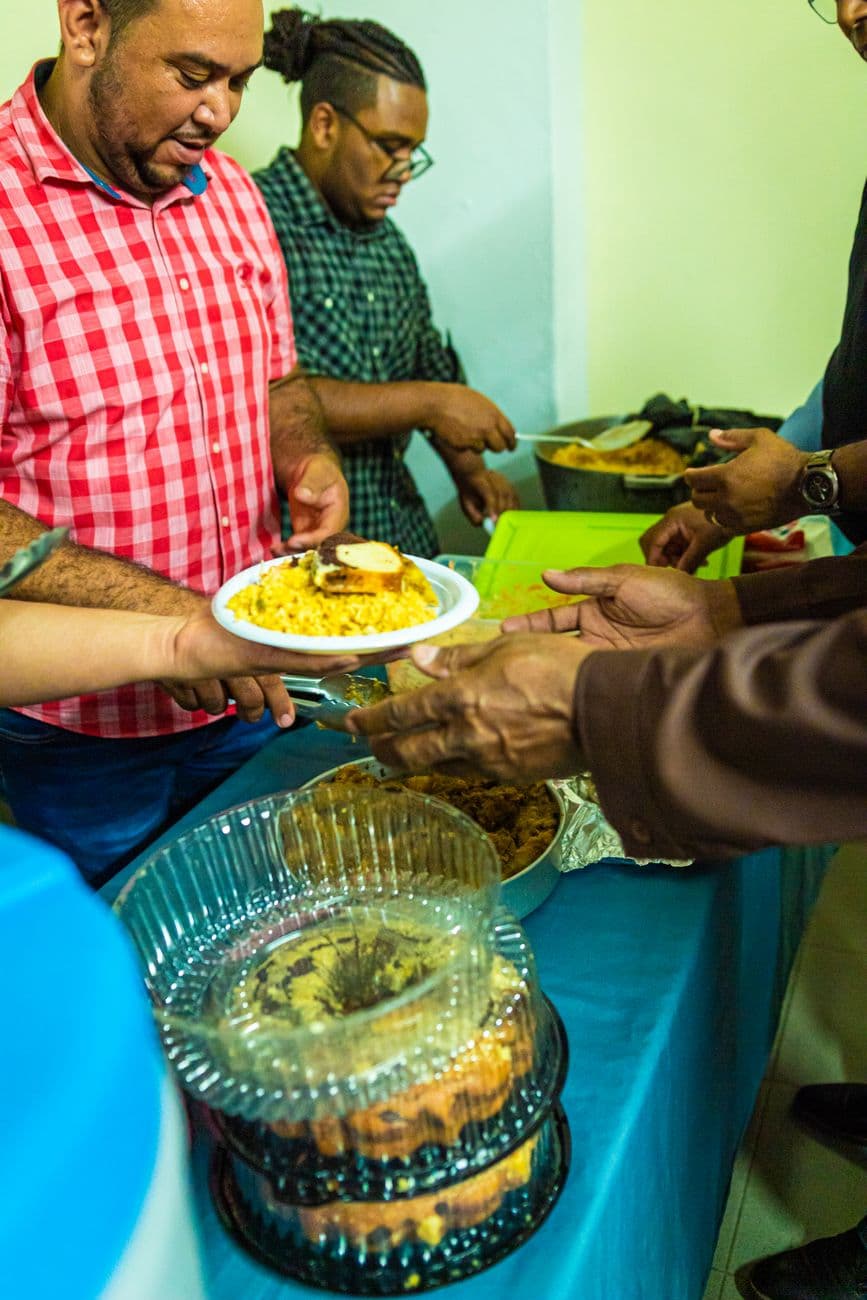 Volunteers serving warm meals at a community event, focusing on togetherness and charity.