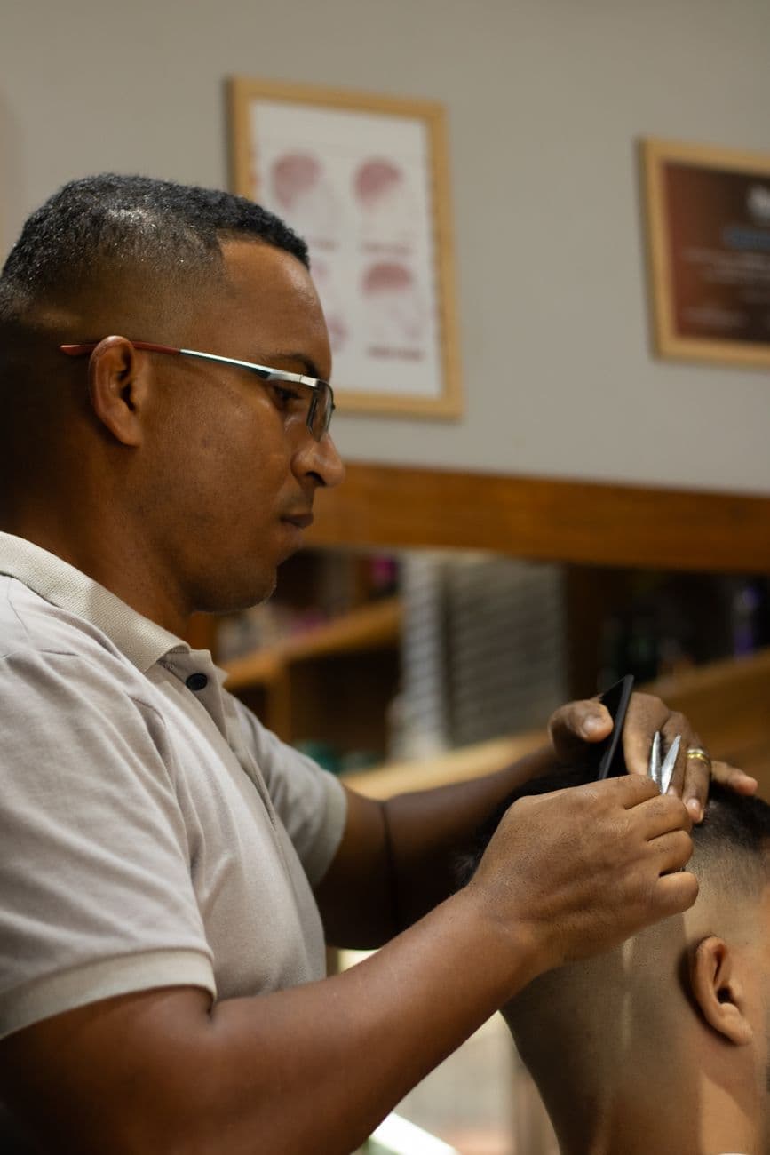 Barber crafting a precise haircut at a stylish salon, showcasing expertise.