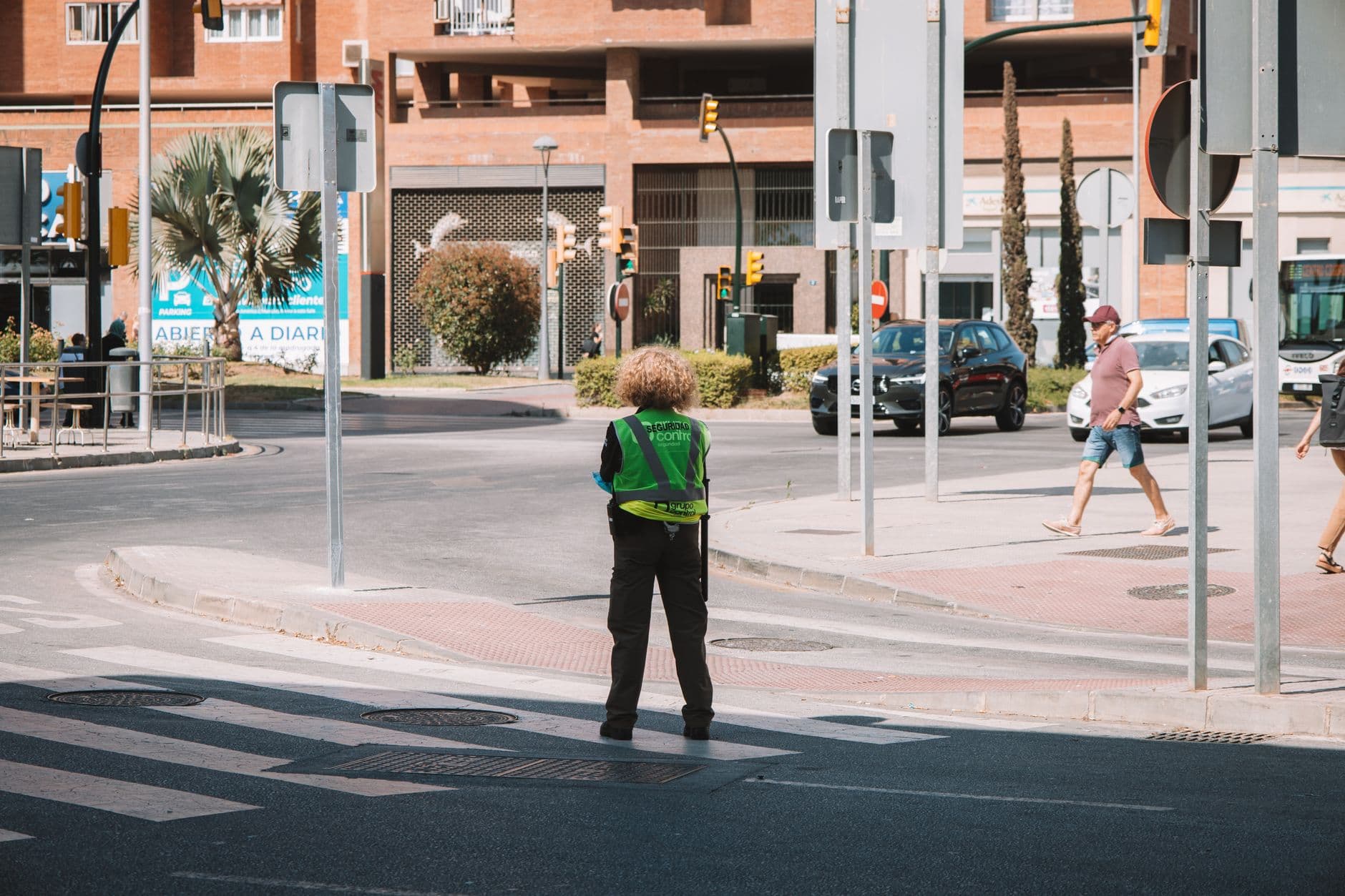 Traffic officer managing city intersection in Málaga, Spain on a sunny day.