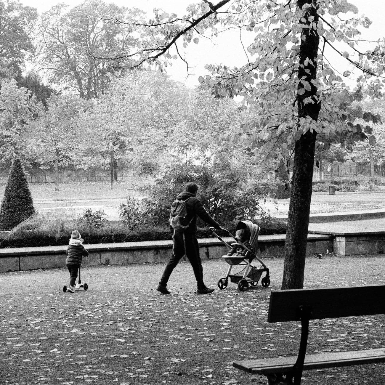 A family enjoying a walk in a leafy Metz park in autumn.