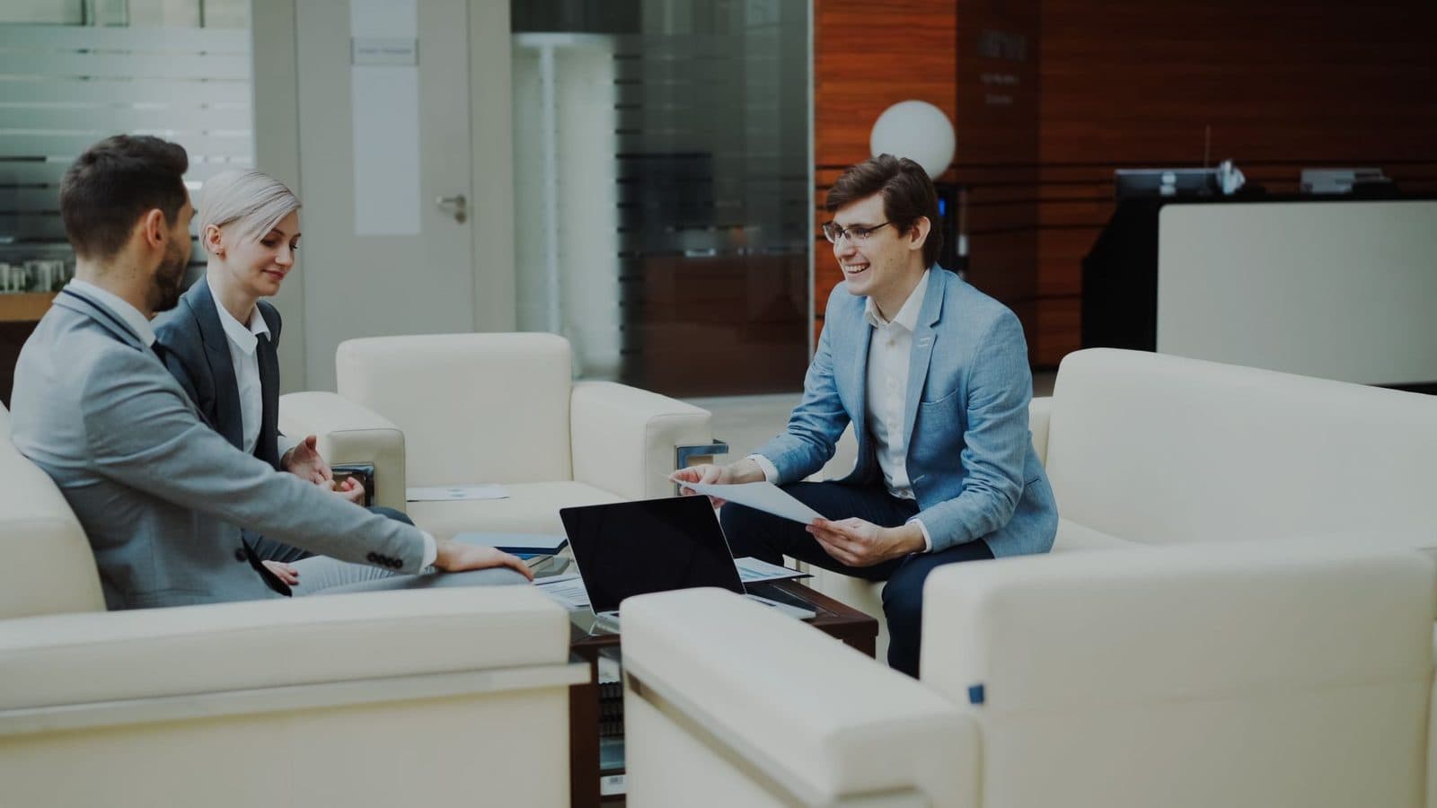 Three professionals having a meeting in a stylish office lounge.