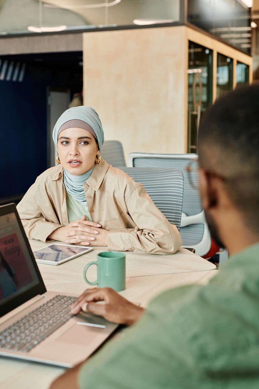 A diverse team engages in a meeting discussing a project in a modern office setting.
