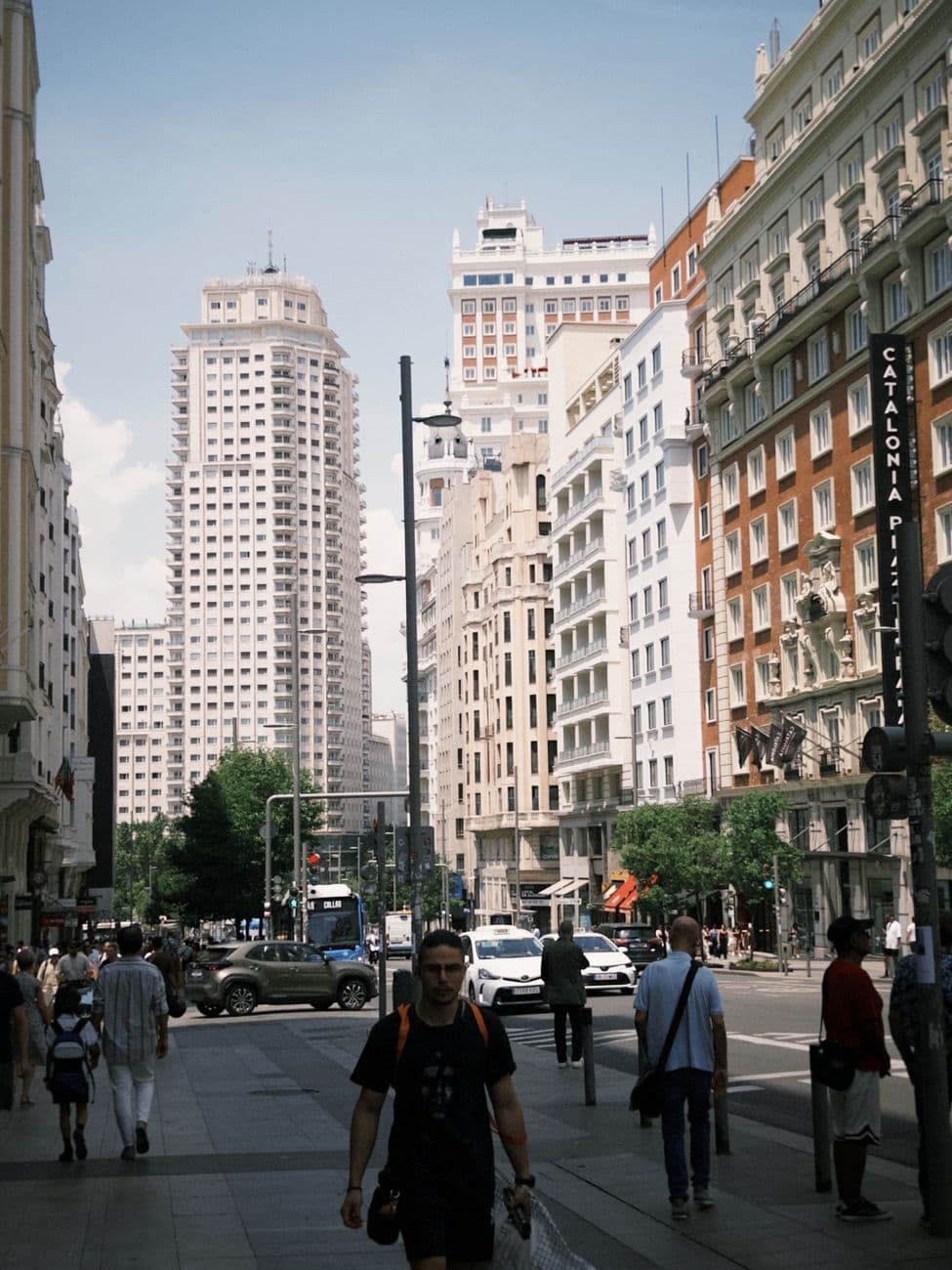 Lively urban street view capturing the essence of Madrid's Gran Vía with bustling pedestrians.