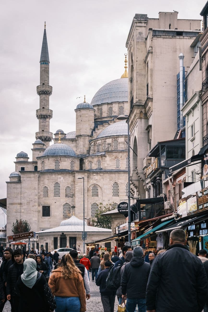 Busy street in Istanbul's Eminönü district near the Yeni Cami (New Mosque), showcasing local life.