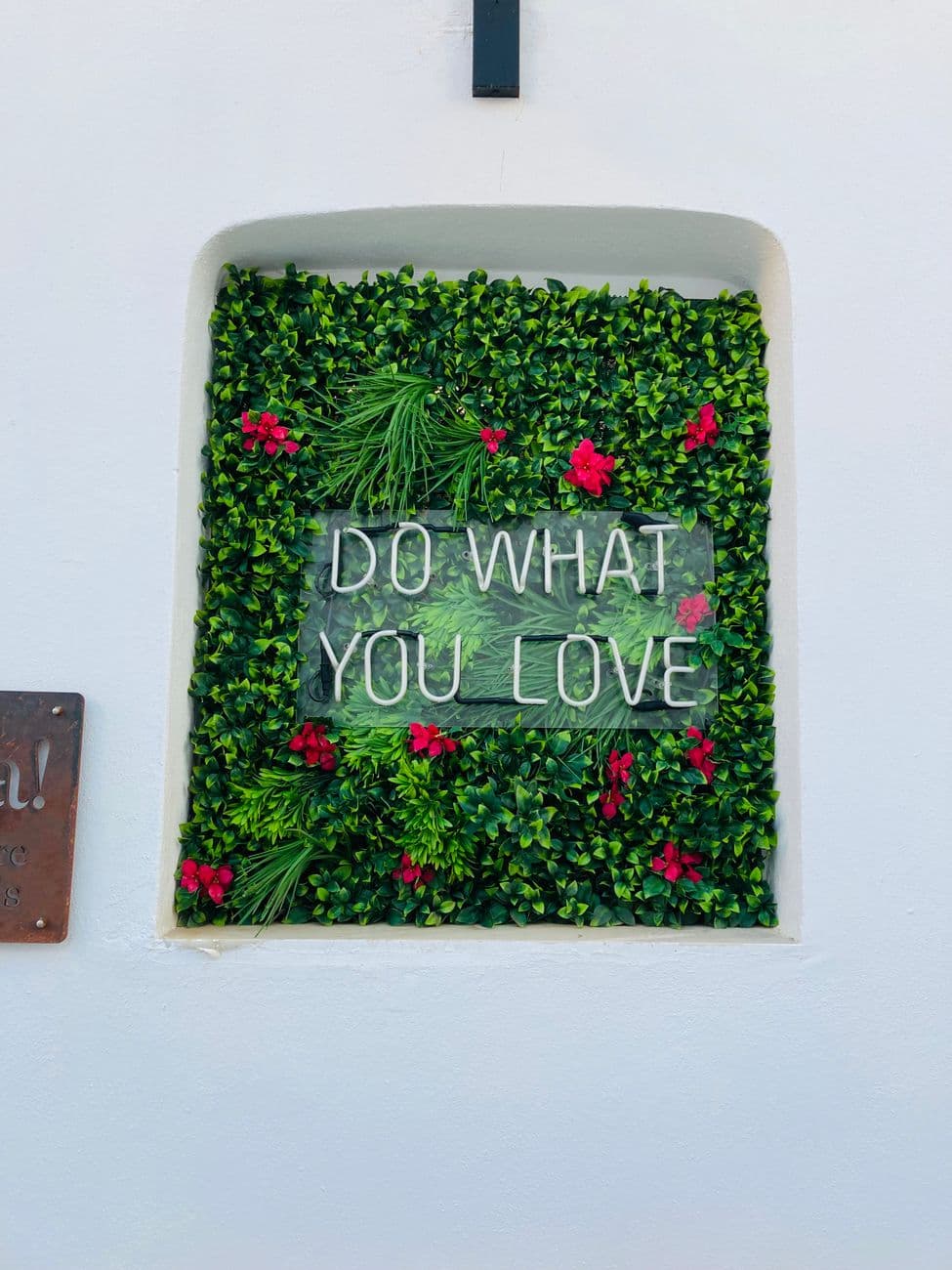 Decorative wall with 'Do What You Love' message in Naousa, Greece. Perfect for inspiration and motivation.