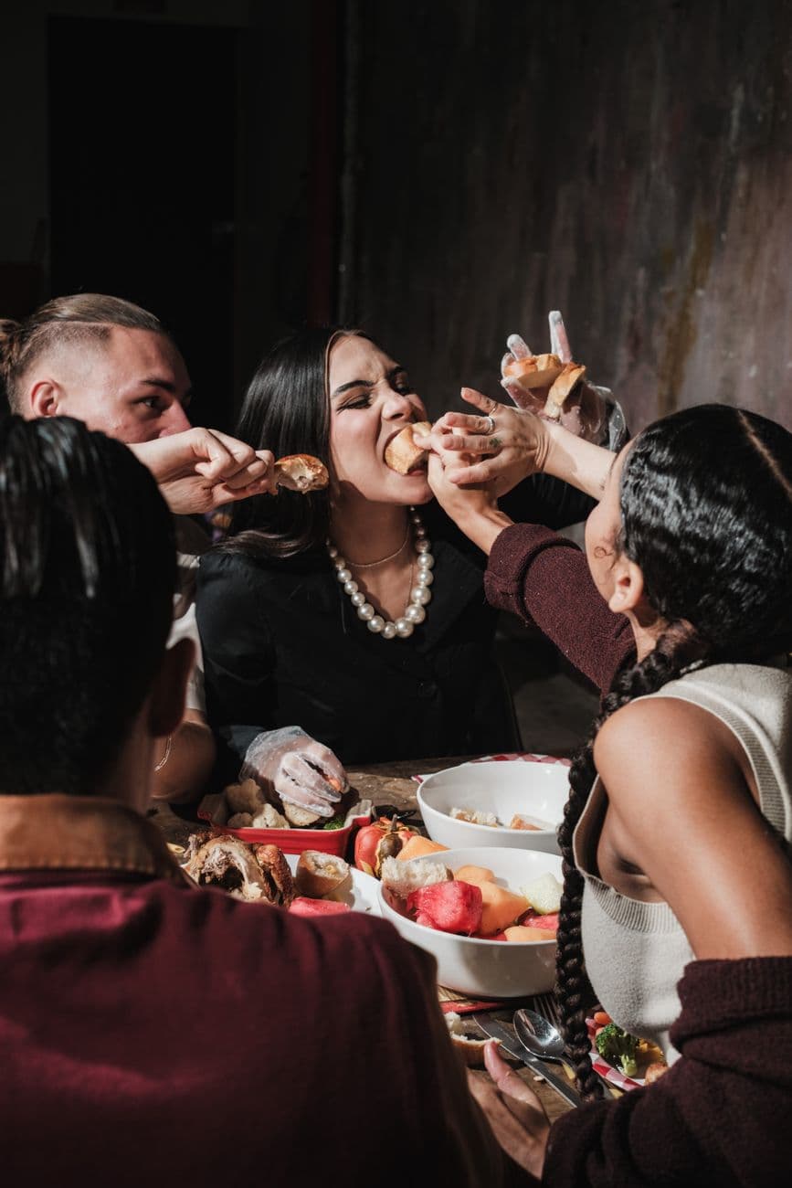 Group of friends enthusiastically sharing a festive Thanksgiving meal together.