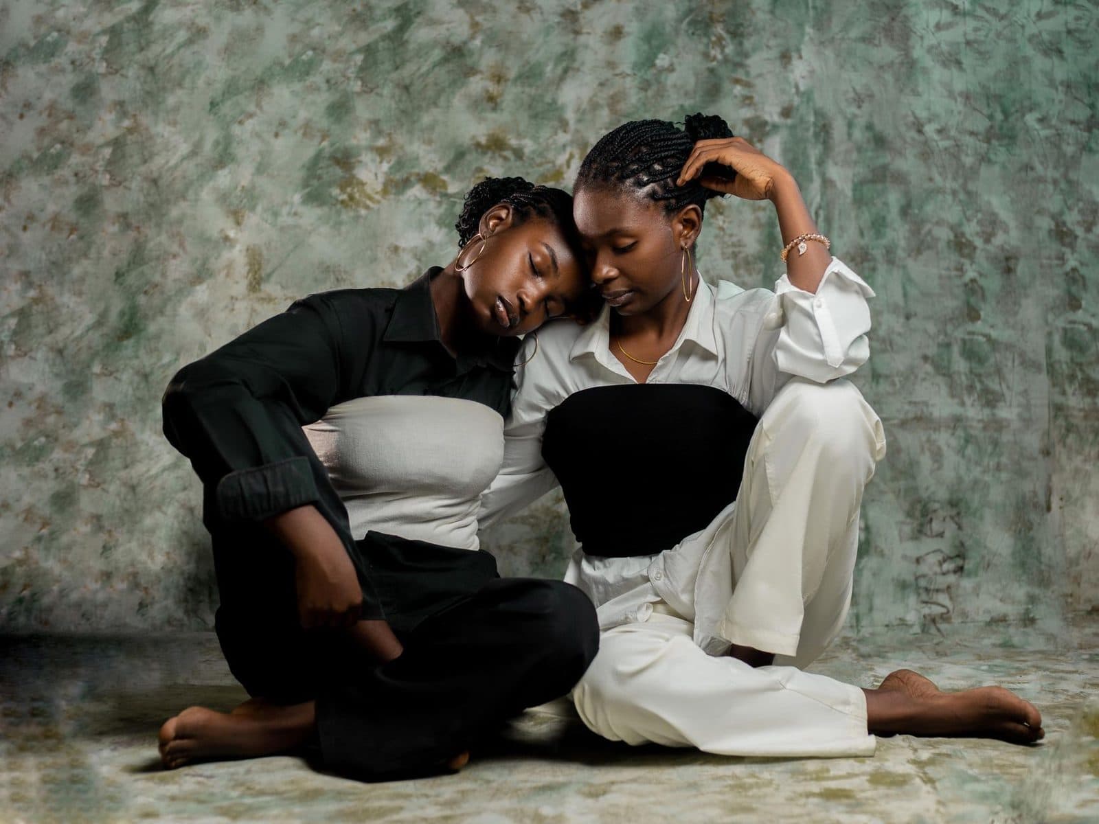 A touching portrait of two women sitting together in an embrace, showcasing friendship and emotional connection.