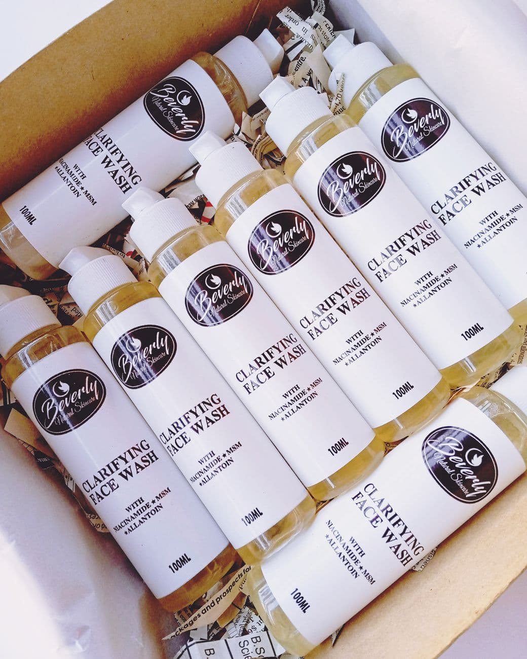 A top view of multiple clarifying face wash bottles neatly arranged in an open box, ideal for skincare use.