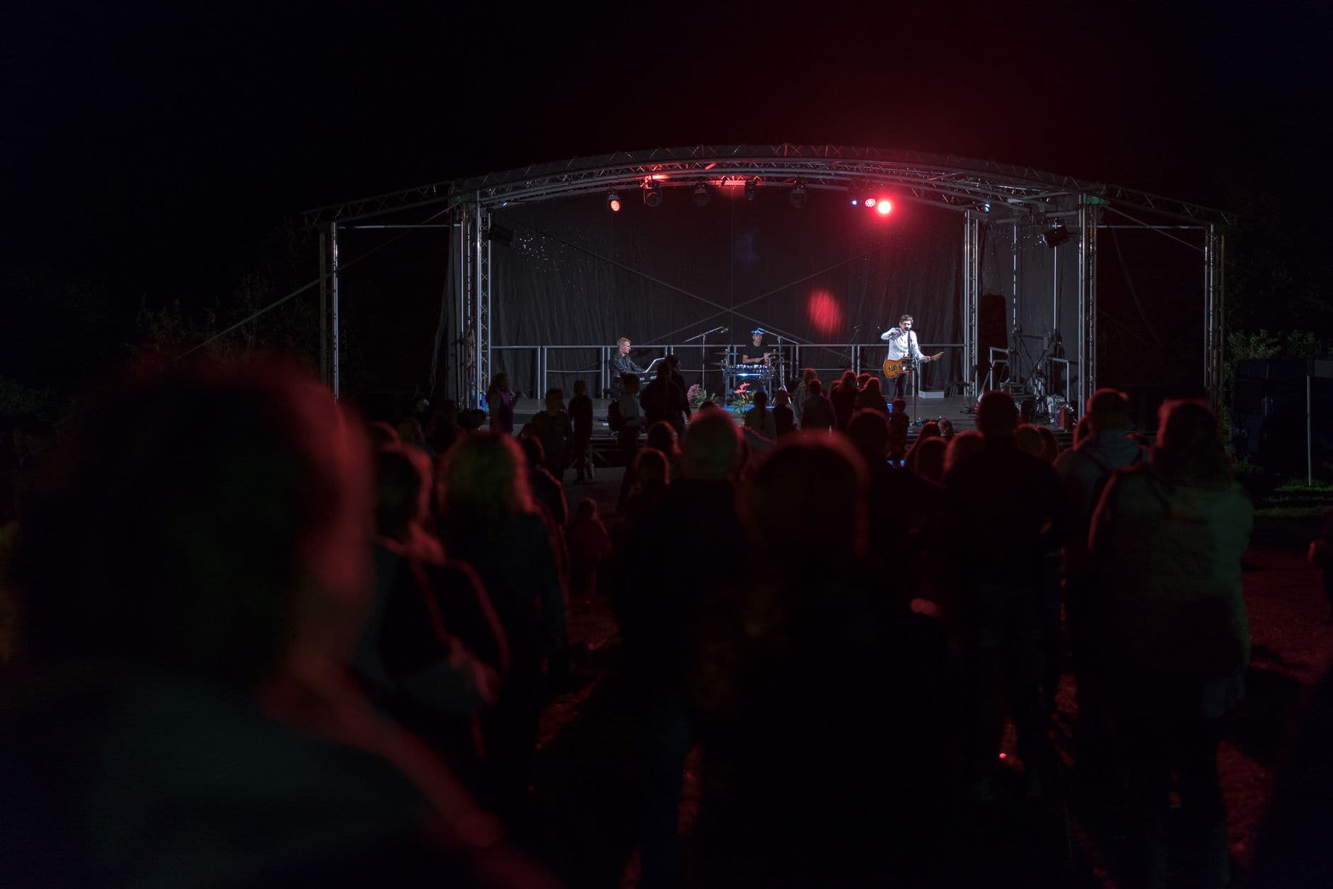 Live music performance at night with a crowd enjoying the concert outdoors in Lithuania.