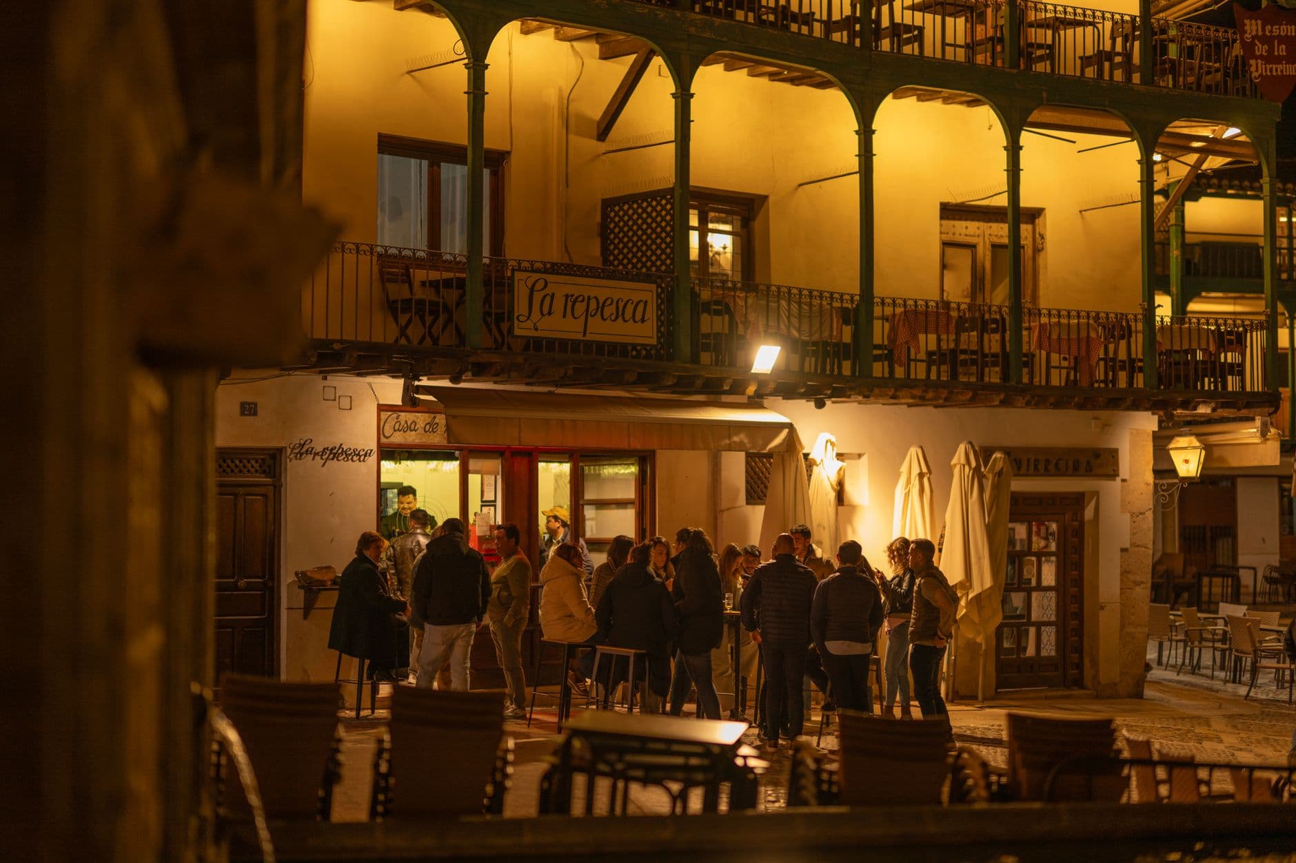 A vibrant evening atmosphere at a traditional Spanish plaza in Chinchón, Madrid.