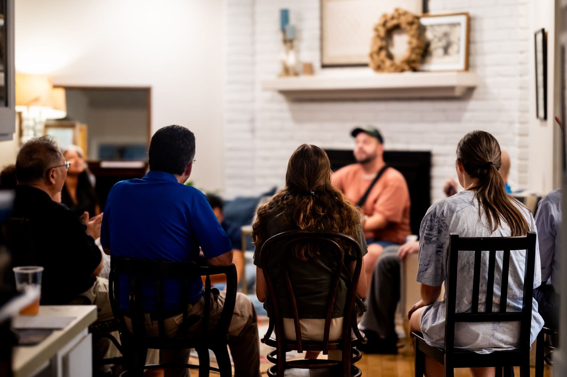 A diverse group engages in a casual conversation in a cozy living room setting.