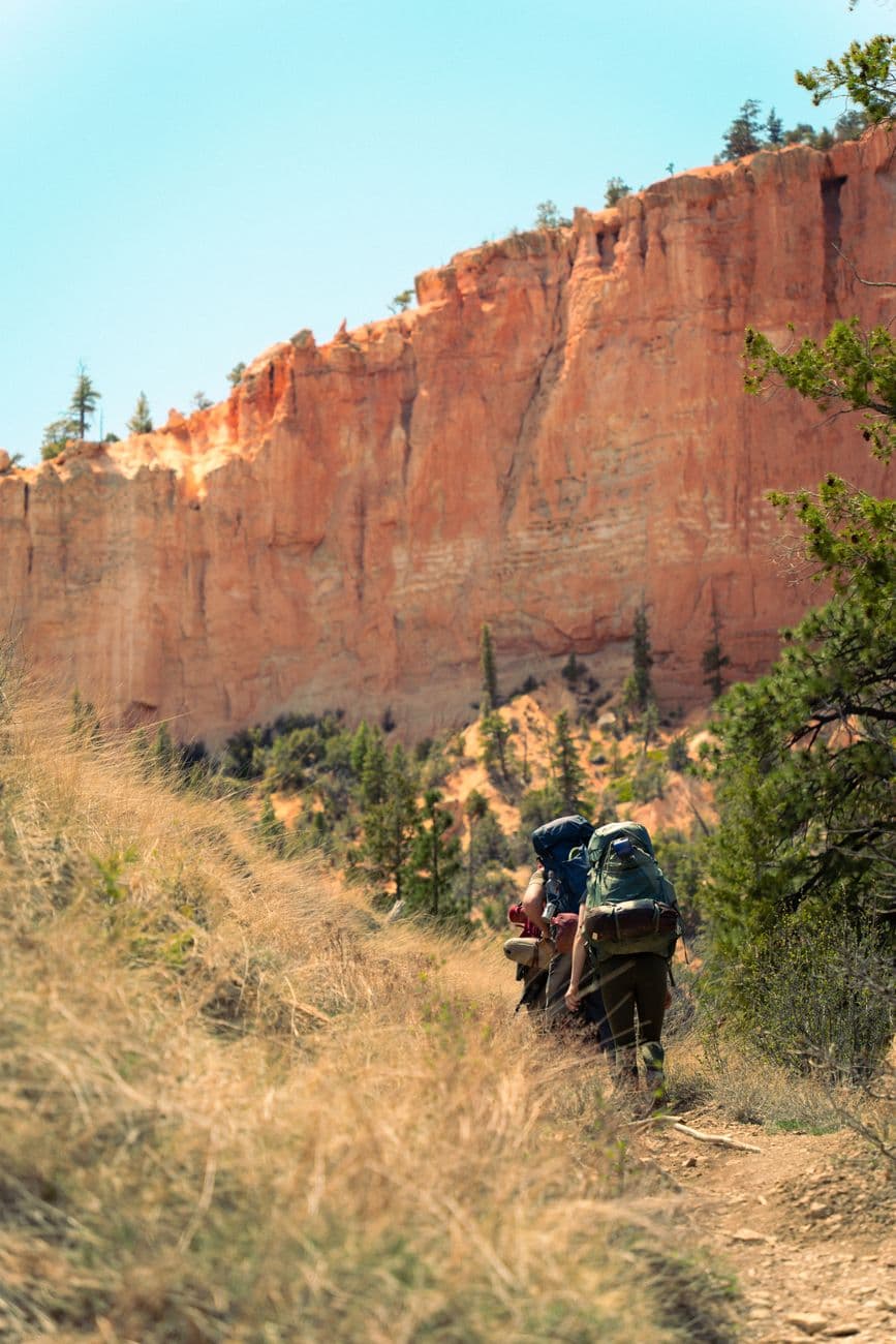Adventurers backpacking through the striking landscape of Bryce Canyon, Utah.