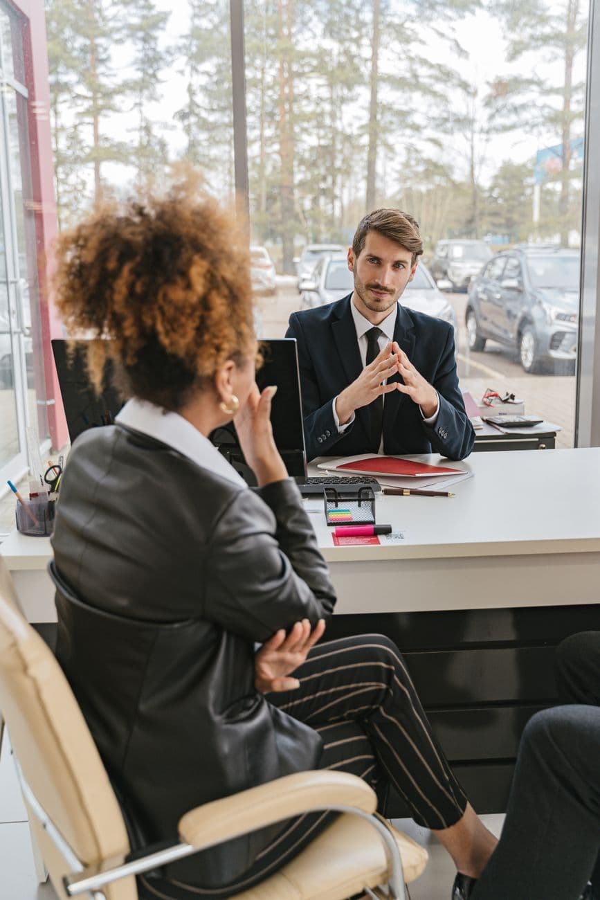 Business professionals engaged in conversation at a modern office desk, discussing ideas and strategies.