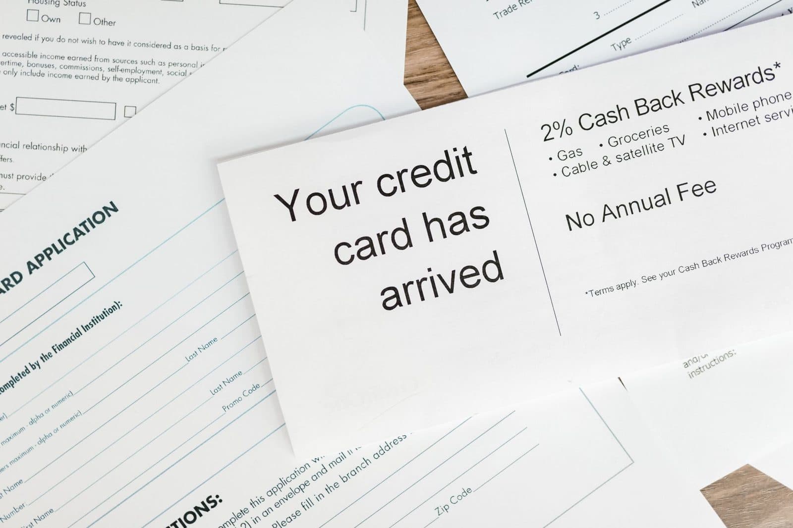 Close-up of a letter announcing the arrival of a credit card amidst financial documents.