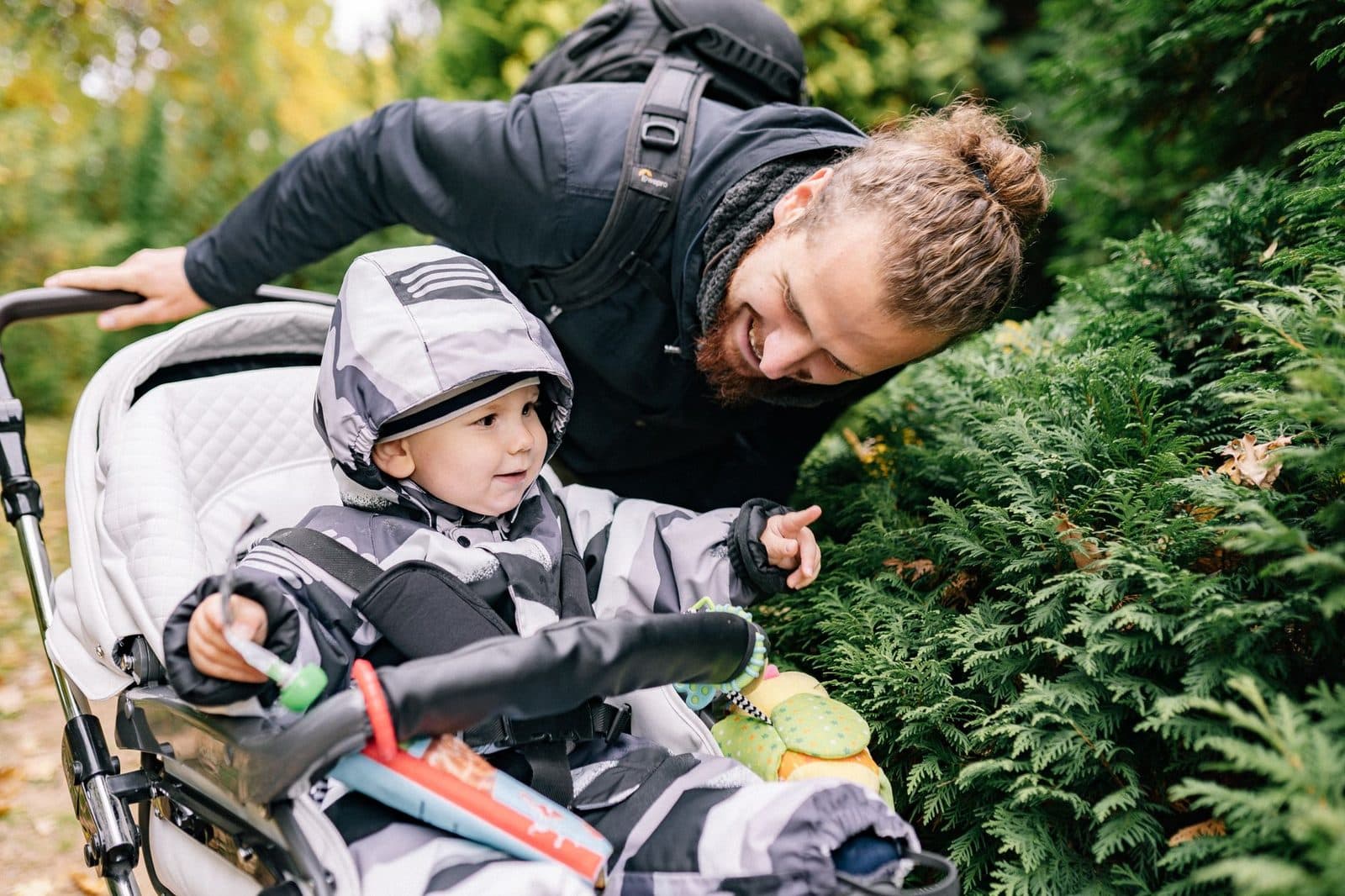 A joyful father and son enjoying quality time outdoors in a stroller.