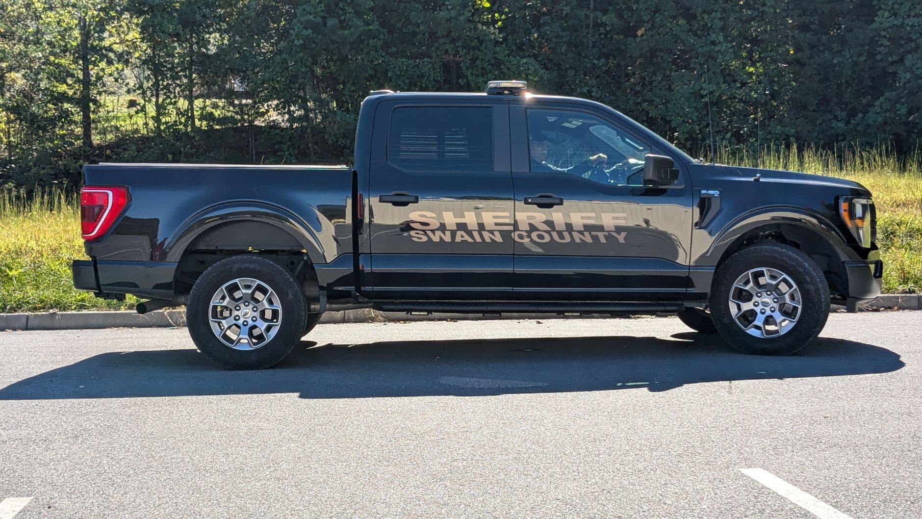 Swain County Sheriff pickup truck parked outdoors in daylight. Side view capture.