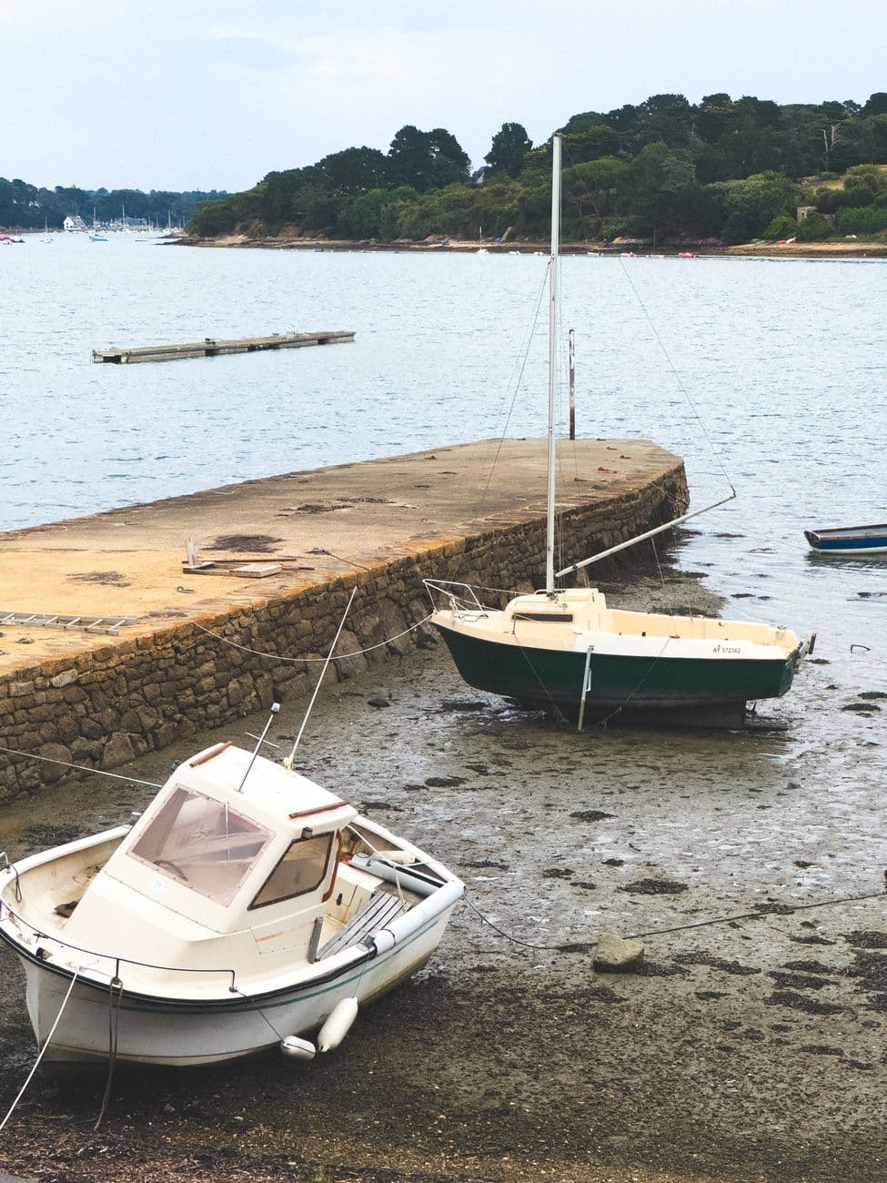 Charming boats on a dock during low tide in Île-aux-Moines, France.