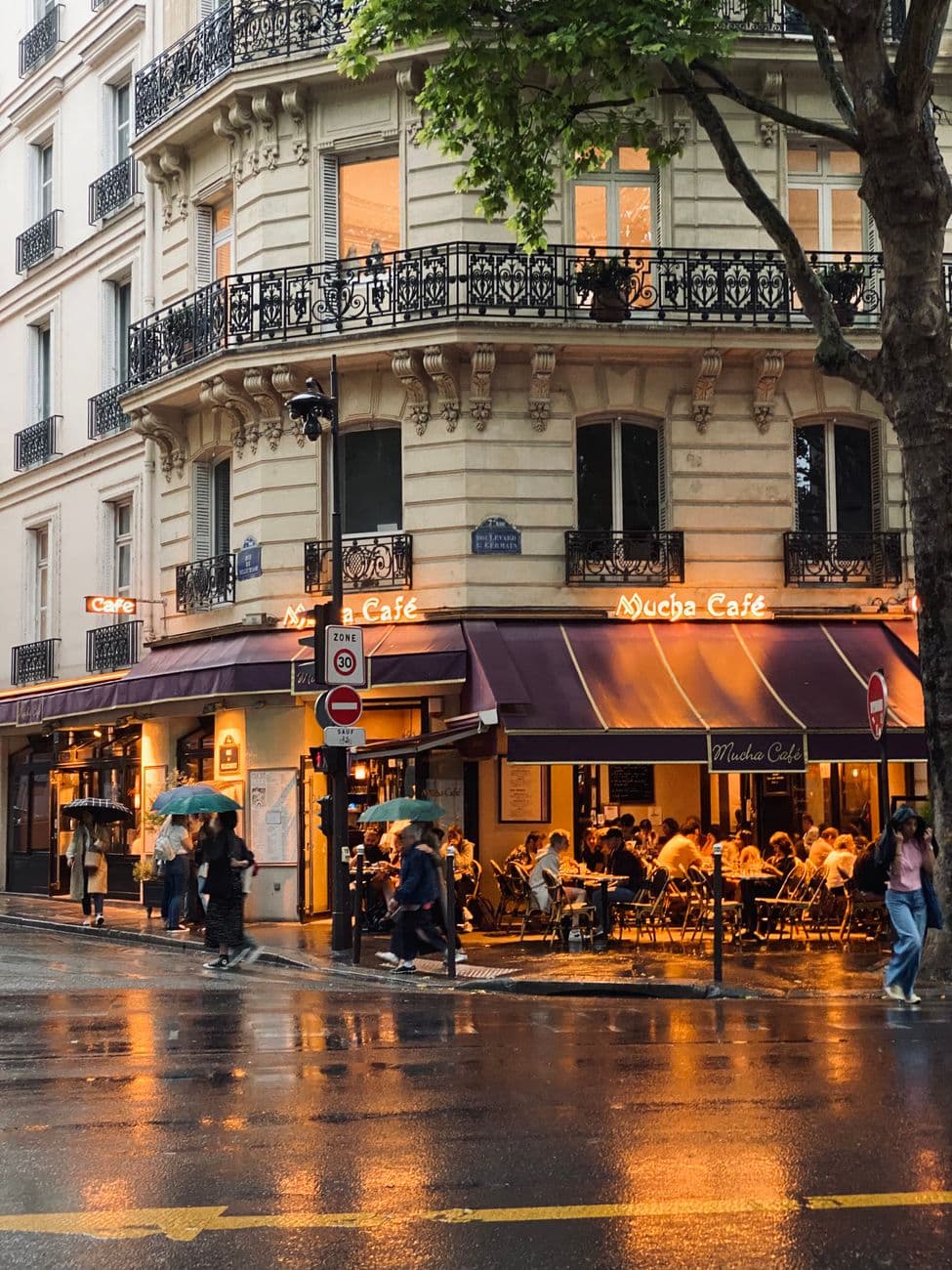 A cozy Parisian café scene with evening lights reflecting on wet streets.