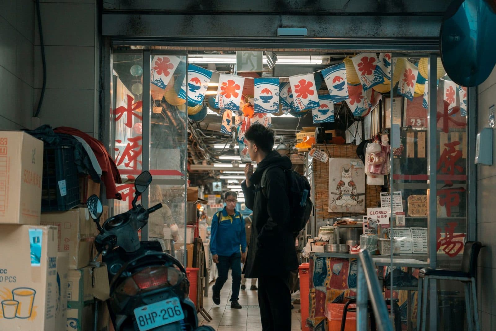 A candid capture of people in a colorful urban market entrance, showcasing vibrant decor and a busy atmosphere.