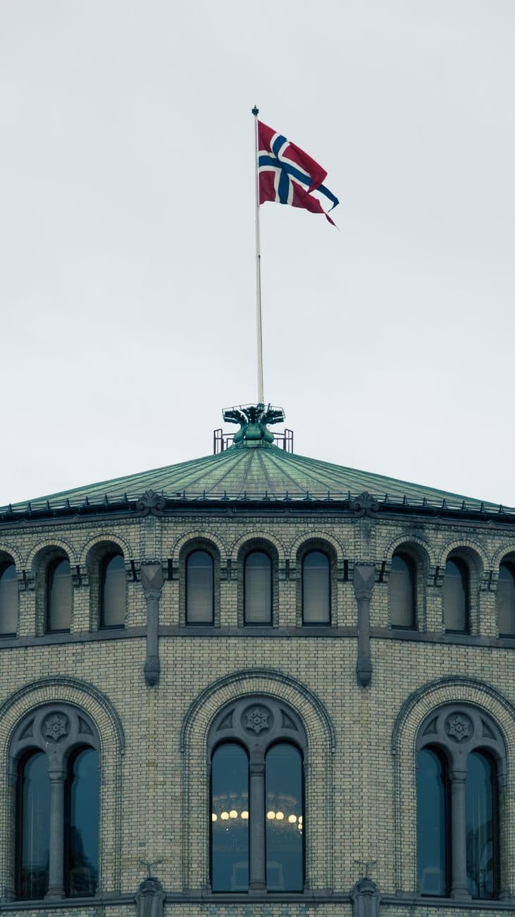 Classic architecture with the Norwegian flag atop a historic building in Sweden.