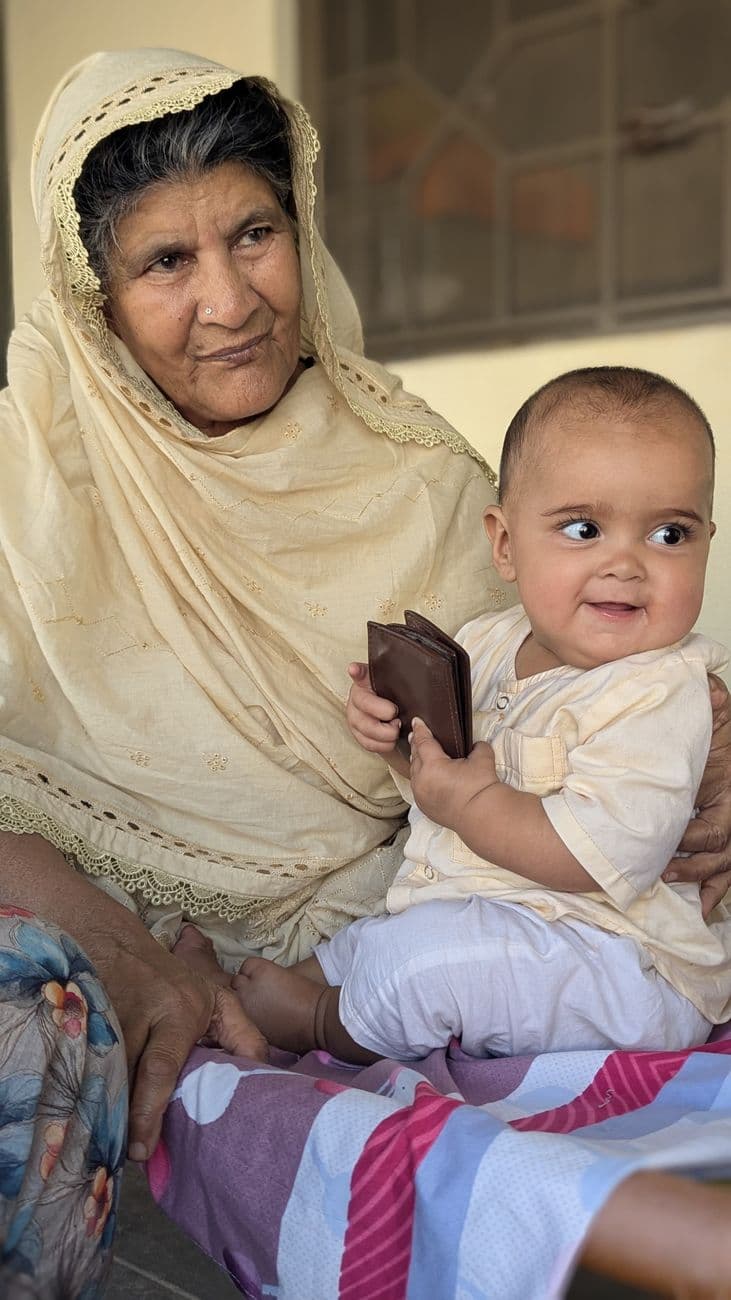 Elderly woman bonding with baby indoors, sharing a loving moment.
