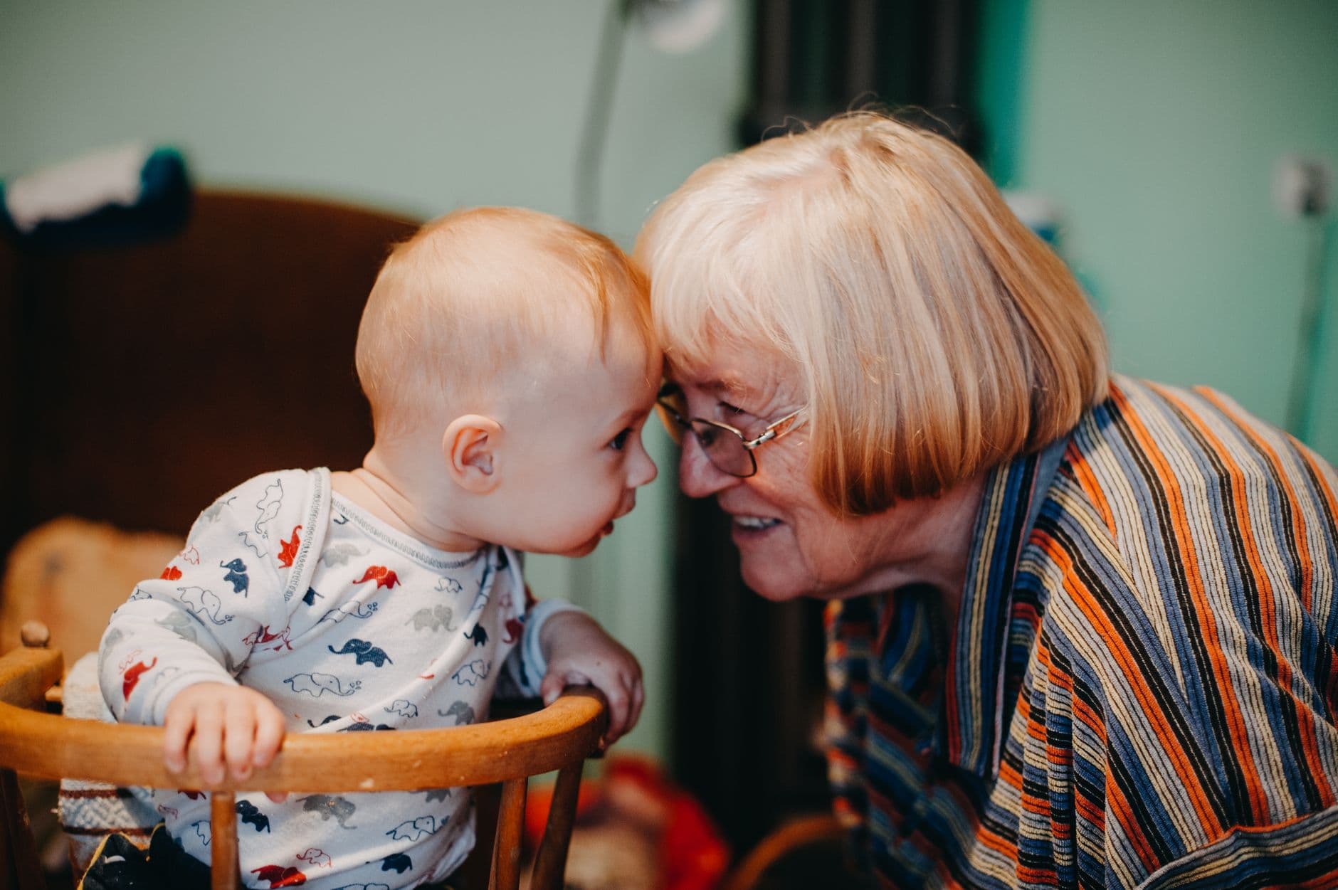 A touching moment shared between a baby and grandmother indoors.