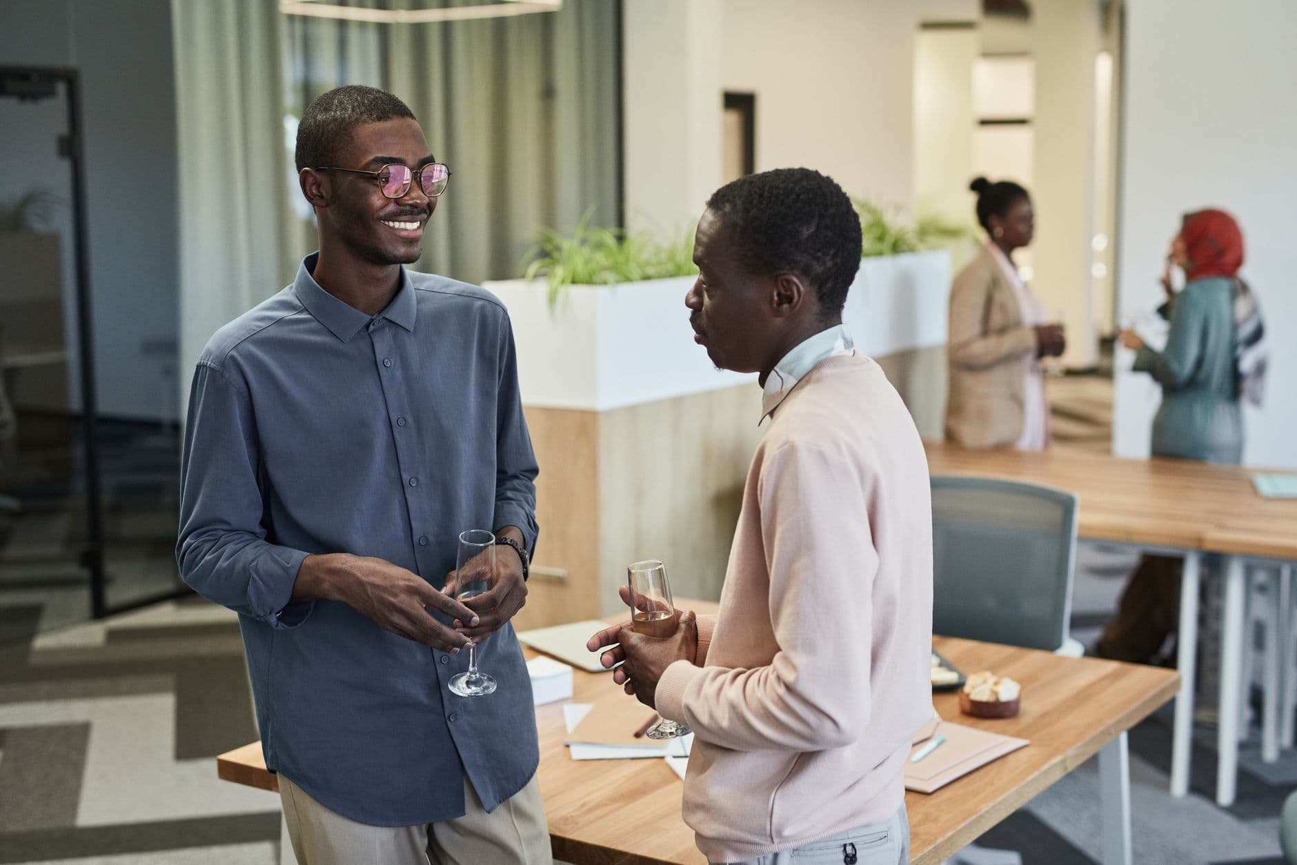 Two colleagues enjoy a light-hearted conversation at an office gathering.