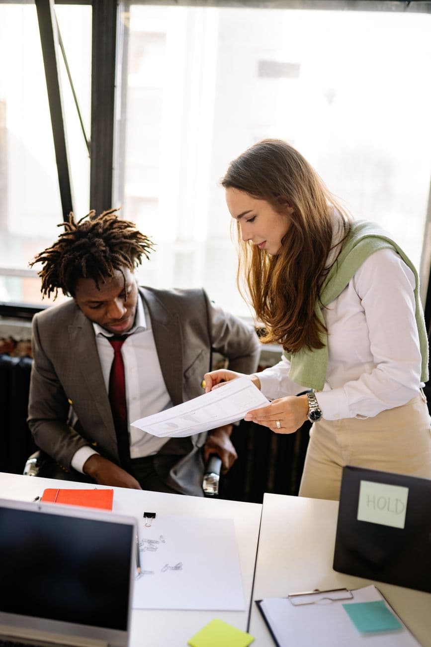 Two colleagues collaborating on a project in a bright, modern office space.